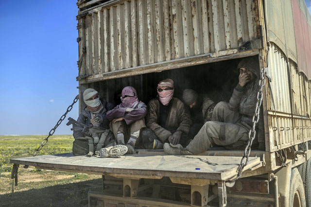 This photo taken on Wednesday shows a truck carrying men, identified as Daesh group militants who surrendered to Kurdish-led Syrian Democratic Forces, as they are transported out of Daesh’s last holdout of Baghouz in Syria's northern Deir Ezzor province (AFP photo)