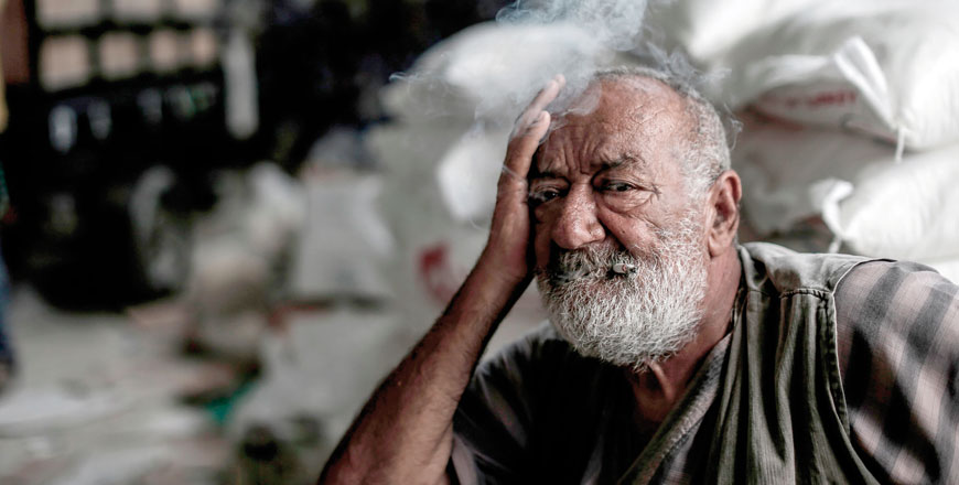 A Palestinian man smokes as he waits to receive aids at a United Nations food distribution centre in Jabalia refugee camp in the northern Gaza Strip on Wednesday (AFP photo)