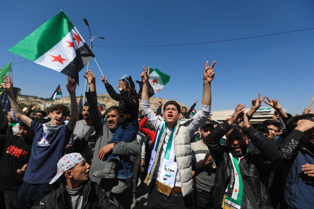 People chant and wave national flags as they celebrate the fourteenth anniversary of Syria's uprising at a rally in Umayyad Square in Damascus today (AFP photo)