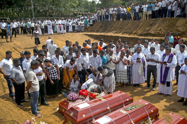   People react during a mass burial of victims, two days after a string of suicide bomb attacks on churches and luxury hotels across the island on Easter Sunday, at a cemetery near St Sebastian Church in Negombo, Sri Lanka, on Tuesday (Reuters)