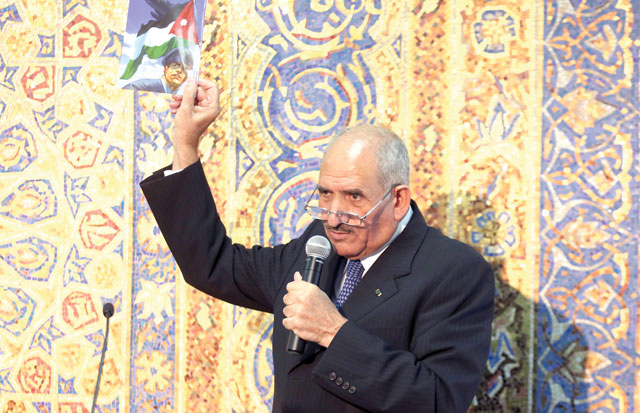 Deputy Prime Minister for Services and Minister of Education Mohammad Thneibat holds a textbook during a press conference at the Prime Ministry on Wednesday (Photo by Raad Adayleh)
