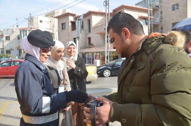 A volunteer serves Arabic coffee to a traffic policewoman in Amman on Wednesday (Photo by Muath Freij)