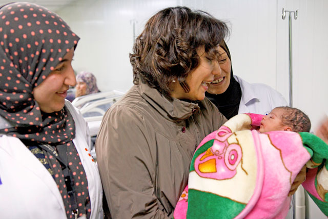 UNFPA Jordan Representative Laila Baker holds a baby born earlier that day at the UNFPA-supported maternity clinic in Zaatari refugee camp (Photo courtesy of UNFPA)