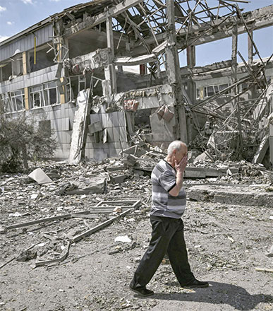 A local resident reacts in front of a destroyed school after a strike in the city of Bakhmut, eastern Ukrainian region of Donbas, on Wednesday (AFP photo)
