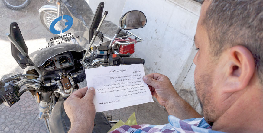 A Syrian man holds a leaflet stamped with the government forces' seal and dropped by helicopters flying over the northwestern Syrian town of Binnish on Thursday (AFP photo)