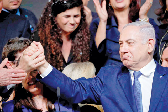 Israeli Prime Minister Benjamin Netanyahu reacts as he shakes hands with someone after addressing supporters at his Likud Party headquarters in the Israeli coastal city of Tel Aviv on election night early on Wednesday (AFP photo)