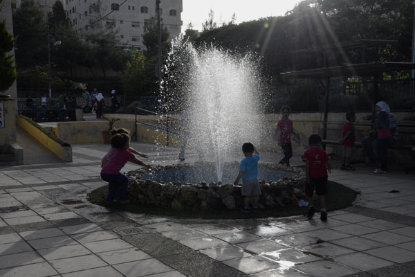 Children play near a water fountain in Amman on Saturday. On Monday, temperatures are forecast to fall back to their annual average during this time of the year (Photo by Amjad Ghsoun)