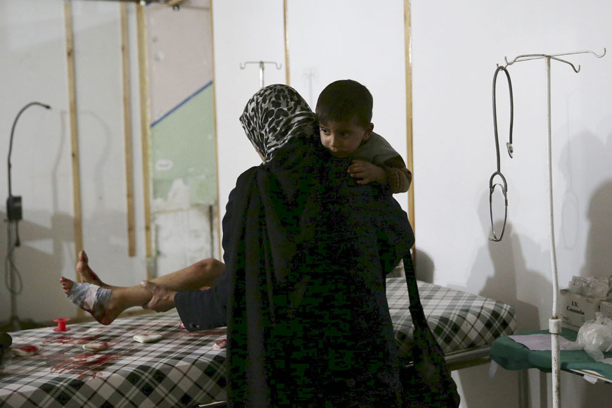 A woman carries her son while tending to the wounds of another son inside a field hospital after what activists said was shelling by forces of Syria's President Bashar Assad in the Douma neighbourhood of Damascus, Eastern Ghouta, Syria on Thursday (Reuters photo)