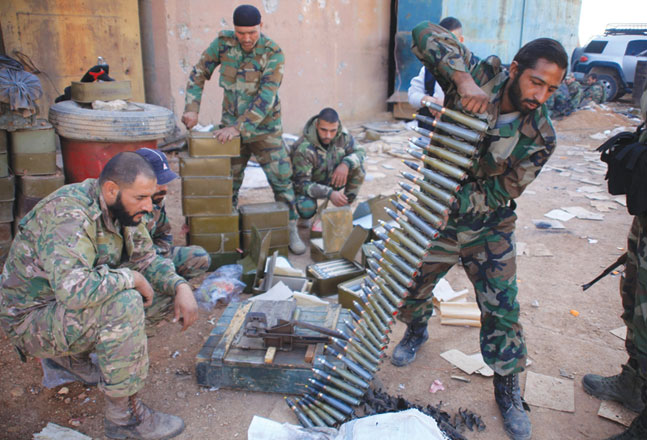 Syrian pro-government forces prepare their weapons at a train station in the area of Arkile near the airport of Kweyris, in the northern Syrian province of Aleppo, on Friday, after they took control of the station and surrounding villages from Daesh militants (AFP photo)