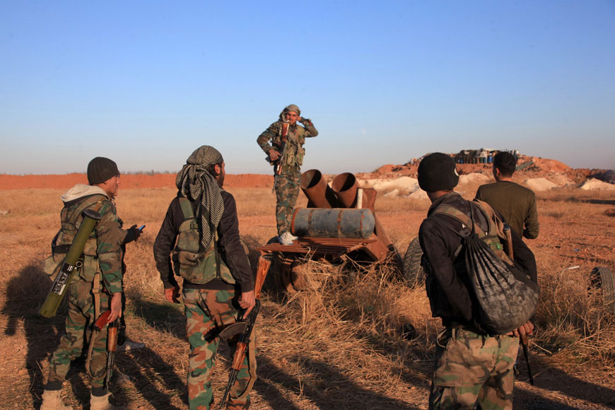 A group of Syrian pro-government forces inspect a home-made rocket launcher during a military operation against the Daesh terror group near the Kweyris military air base, in the east of the northern Syrian province of Aleppo, on Monday (AFP photo)