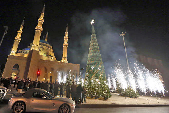 People watch fireworks during the illumination of a giant Christmas tree at the launch of 2015 Christmas festivities, in front of Muhammad Al Amin Mosque in Beirut, Lebanon, Friday (AP photo)
