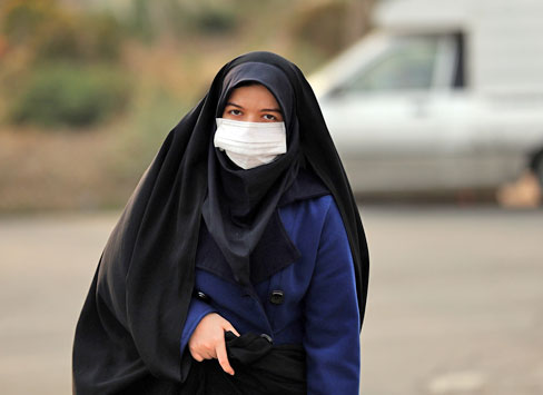 An Iranian schoolgirl wears a facemask as she walks in a heavily polluted area in Tehran on Saturday (AFP photo)