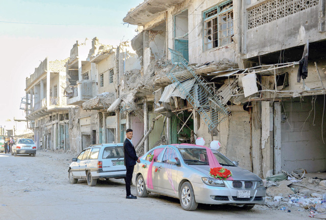 An Iraqi youth stands next to a car that has been decorated for the first wedding in the old city of Mosul a year after the city was retaken by the Iraqi government forces. Iraqi forces announced the ‘liberation’ of the country's second city on July 10, 2017, after a bloody nine-month offensive to end the Daesh militant group's three-year rule there (AFP photo)