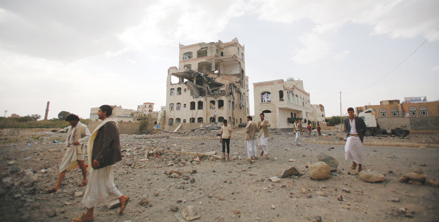 Shiite rebels, known as Houthis, gather at the site of a building destroyed by a Saudi-led air strike in Sanaa, Yemen, Monday (AP photo)