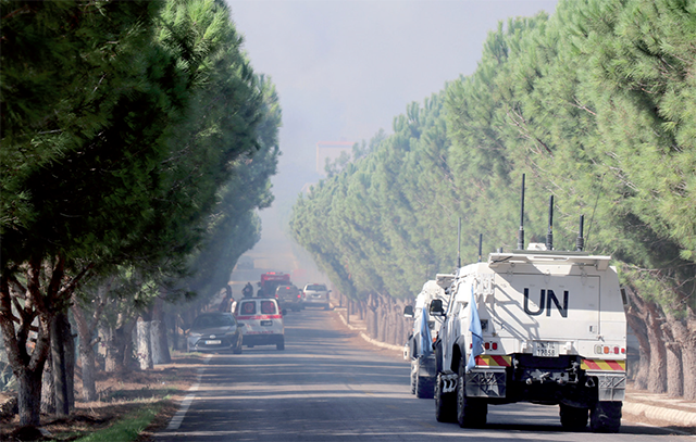 United Nations Interim Force in Lebanon (UNIFIL) vehicles arrive at the scene as civil defence volunteers extiguish a forest fire which reportedly ignited following shelling from Israel in Alma Al Shaab, close to the southern Lebanese border with Israel on Thursday (AFP photo)