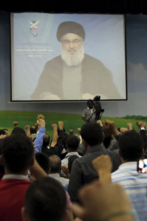 Lebanon's Hizbollah leader Sayyed Hassan Nasrallah addresses his supporters through a giant screen during the group's ceremony to honour the children of its fallen fighters in Beirut on Saturday (Reuters photo)