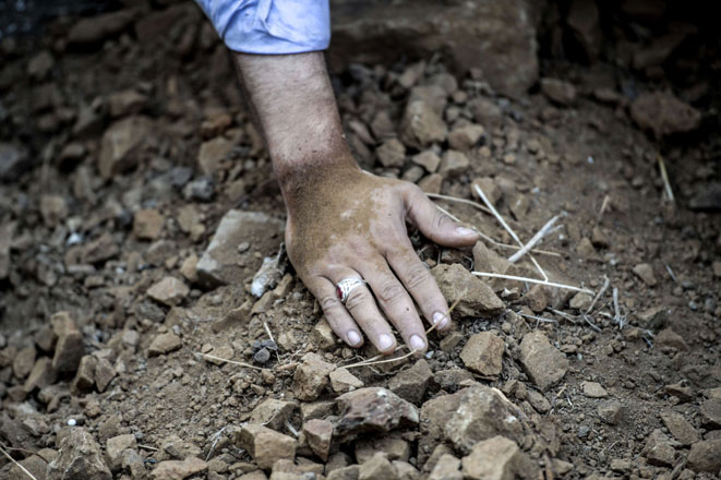 A mourner touches the grave of Vatan Budak, a victim of the suicide bomb attack in Suruc on July 22, during his funeral on Tuesday (AFP photo)