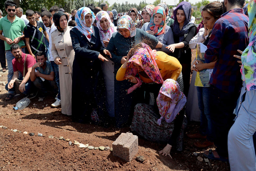 Relatives mourn over the graves of two fighters of the Kurdish People's Protection Units during their funeral in Diyarbakir in southeastern Turkey after the bodies of 13 militants were repatriated from Iraq on Wednesday. Europe and the United States urged Turkey to show a ‘proportionate response’ in the face of daily attacks by Kurdish militants amid growing concern over the scale of Ankara's air campaign against the rebels (AFP photo)
