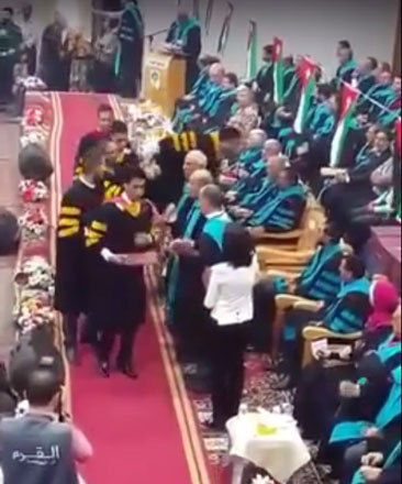 In this image grab taken from a video uploaded on YouTube earlier this week, a student is seen spitting at a faculty member during a graduation ceremony at Jadara University in Irbid, some 80km north of Amman (JT photo)