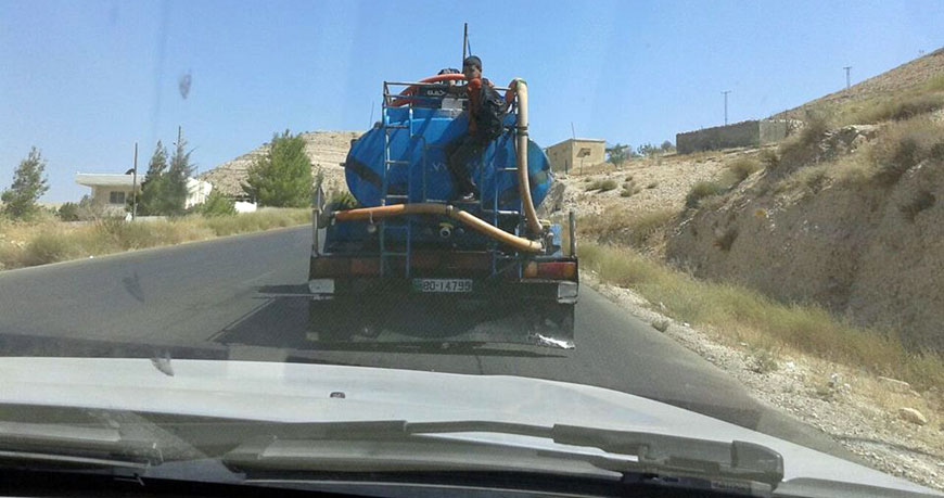 A student hitches a ride on a water tanker to reach school, as his old school was merged with another one located farther from his home, according to the Jordan Teachers Association  (Photo courtesy of JTA)