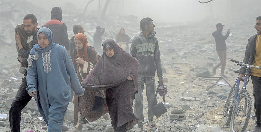 Palestinians flee the area after Israeli bombardment in central Gaza City on Monday, amid the ongoing battles between Israel and Hamas (AFP photo)