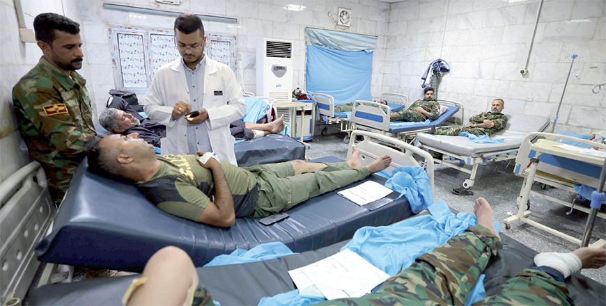Iraqi military personnel receive treatment at a hospital in Hilla in the central province of Babylon after they were wounded in an alleged bombing overnight on an Iraqi military base housing a coalition of pro-Iranian armed groups, on Saturday (AFP photo)