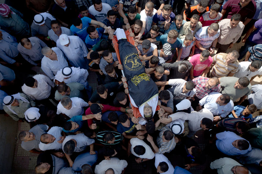 Palestinian mourners carry the body of Dia Al Talahmeh, 21, covered with the flag of the Islamic Jihad group, during his funeral in the West Bank village of Khursa, near Hebron, Tuesday (AP photo)