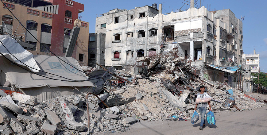 A Palestinian man walks past a destroyed building in Rafah in the southern Gaza Strip on Sunday (AFP photo)