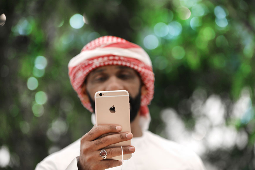 In this Tuesday photo, a journalist checks out a mobile phone at the Apple Store ahead of their Grand Opening in Dubai , United Arab Emirates (AP photo)