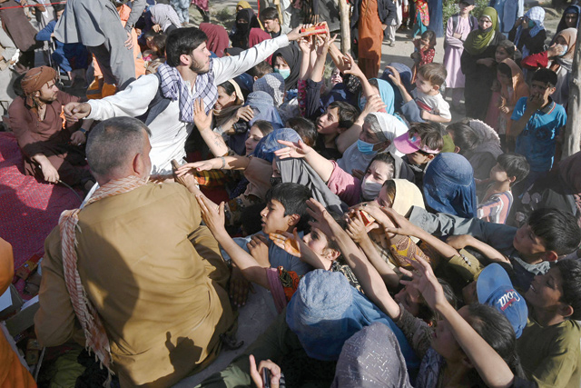 Internally displaced Afghan families fled from Kunduz and Takhar province due to battles between Taliban and Afghan security forces, collect food in Kabul on Monday (AFP photo)