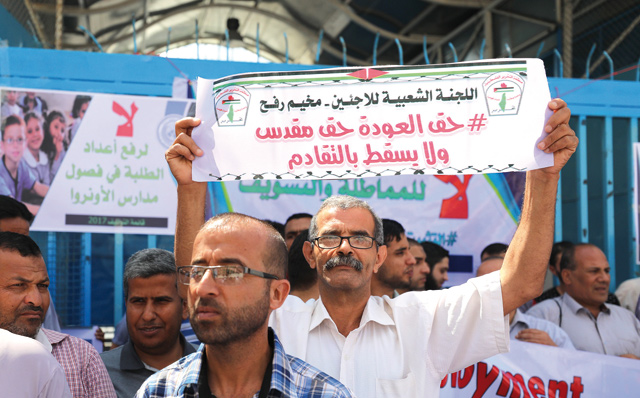 United Nations Relief and Works Agency for Palestine Refugees in the Near East (UNRWA) staff hold banners during a protest as they demand the protection of workers' rights and basic services that UNRWA offers to refugees in Gaza City, Gaza, on Thursday (Anadolu Agency photo)