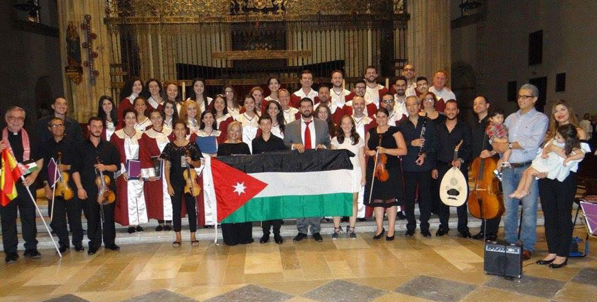 The choir’s founder and conductor Tomah Jbarah (middle) poses for a group photo with the choir members outside a church in Spain in July (Photo courtesy of Tomah Jbarah)