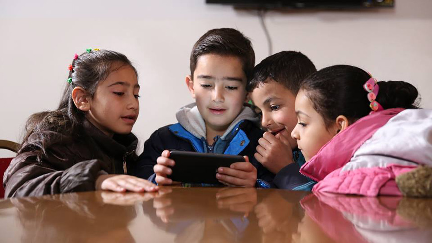 Children are seen playing the Antura and the Letters educational game on a mobile phone  (Photo courtesy of Antura and the Letters’ website)