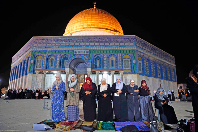 Palestinian women pray in front of the Dome of the Rock at Al Aqsa Mosque/Al Haram Al Sharif compound in the Old City of Jerusalem on Monday  (AFP photo by Ahmad Gharabli)