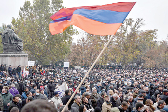 A man waves a flag of the breakaway Nagorno-Karabakh region during a rally against a controversial peace agreement with Azerbaijan in Yerevan on December 5 (AFP photo)