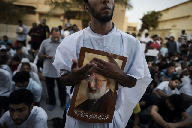 Bahraini demonstrators attend a protest against the revocation of the citizenship of top Bahraini Shiite cleric Isa Qassim (portrait), on Monday near Qassim's house in the village of Diraz, west of Manama (AFP photo)