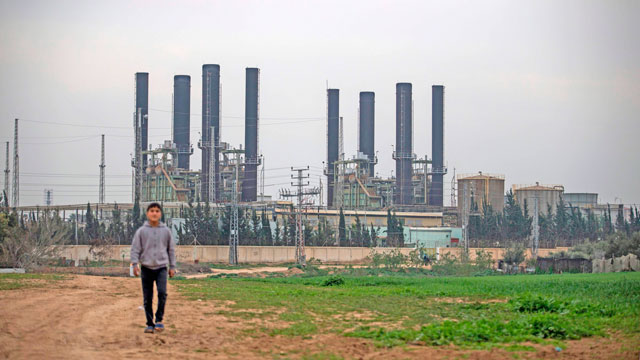 A Palestinian youth walks back from the Gaza Strip's sole electricity plant, which provides a fifth of the embattled region's power needs, on Thursday, after it stopped working at midnight the previous night due to lack of fuel as per local officials (AFP photo)