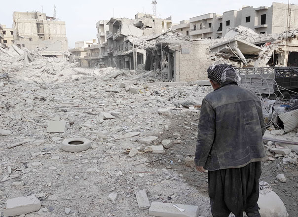 This photo taken on Monday shows a man looking at the damage in the Syrian Kurdish city of Afrin a day after Turkish-led forces entered the city (AFP photo)