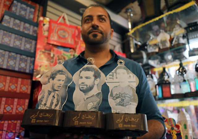 Mohamed Gamal works on lanterns with portraits of Egyptian professional football players; Stoke City's Ramadan Sohby (left), AC Roma's Mohamed Salah (centre), and FC Basel's Omar Gaber, in Cairo, Egypt, on May 16 (Reuters photo)