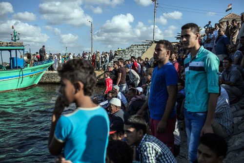 In this September 22 photo, Egyptians wait on shore as a coast guard boat arrives carrying the bodies recovered from a Europe-bound boat that capsized off Egypt's Mediterranean coast, in Rosetta, Egypt (AP photo)