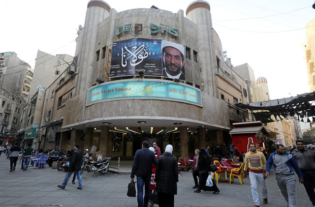 Egyptians walk past an advertisement featuring the Egyptian film ‘Mawlana’ (‘The Preacher’) at a cinema in Cairo, Egypt, on Monday (Reuters photo)