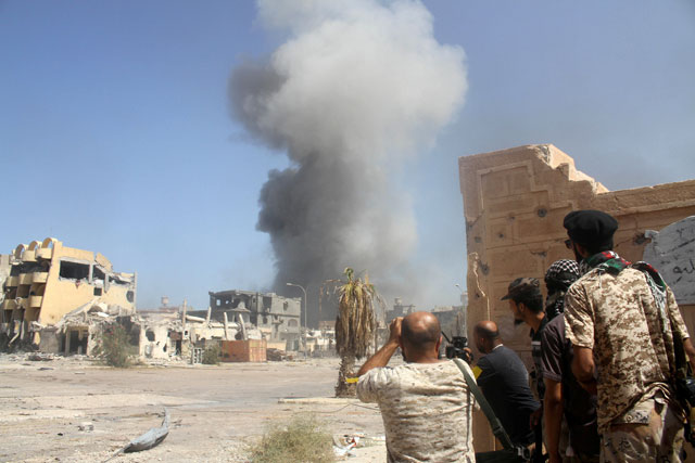 Smoke rises as Libyan forces allied with the UN-backed government take cover during a battle with Daesh militants in Sirte on October 2 (Reuters photo)