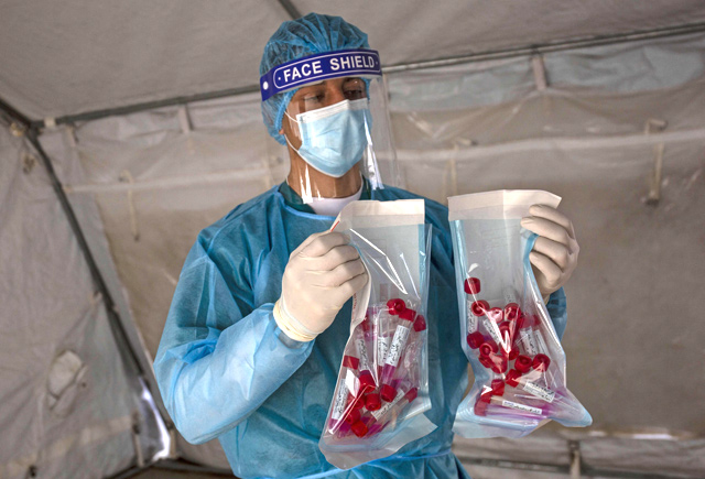 A Palestinian health worker arranges swab samples collected to test for COVID-19 in Rafah in the southern Gaza Strip, on Tuesday (AFP photo)