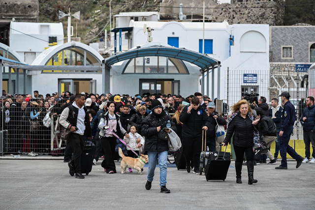 People walk on the platform to embark a ferry as they prepare to leave in the wake of recurring earthquakes, on the Greek Island of Santorini on February 4, 2025 (AFP photo)