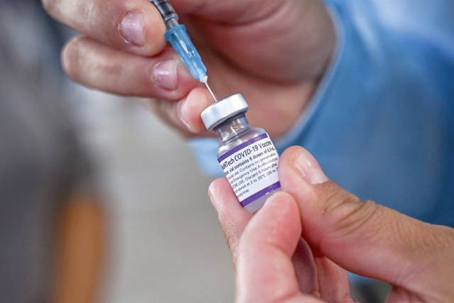 A nurse prepares a dose of the Pfizer-BioNtech COVID-19 vaccine before vaccinating a boy at a school in Medellin, Colombia, on Tuesday amid the ongoing coronavirus pandemic (AFP photo)