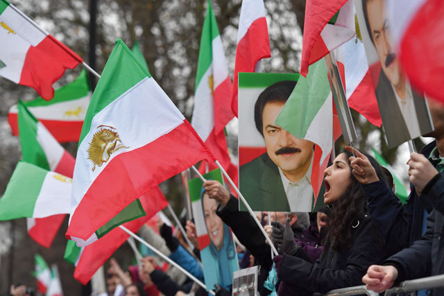 Protesters wave flags as they gather outside the Iranian embassy in central London on Tuesday, in support of national demonstrations in Iran against the existing regime (AFP photo)