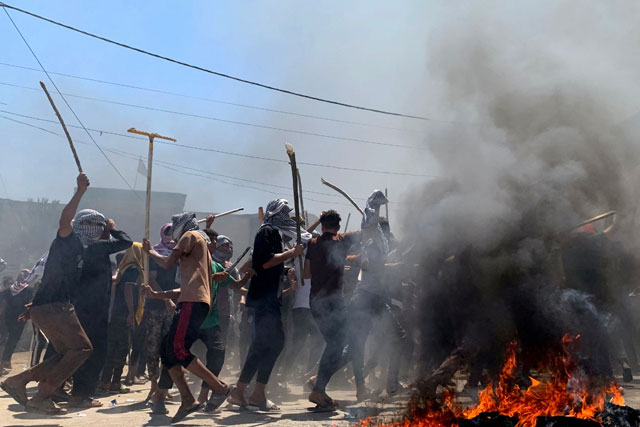 Iraqi demonstrators burn tyres in front of the mayor's offices to protest against daily power cuts and water shortages during the extreme heat of summer, in Al Mahnawiya, in the southern Iraqi province of Diwaniyah on July 21, 2024 (AFP Photo)