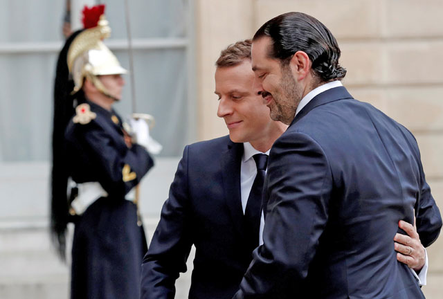French President Emmanuel Macron and Saad Al Hariri, who announced his resignation as Lebanon's prime minister while on a visit to Saudi Arabia, walk together in the courtyard of the Elysee Palace in Paris, France, on Saturday (Reuters photo)