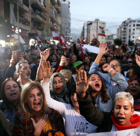 Lebanese women, from the Chrisitan-dominated neighbourhood of Ain Al Remmaneh and Shiite-dominated neighbourhood of Shiah, shout slogans as they march through Beirut’s former demarcation line on Wednesday (AFP photo)