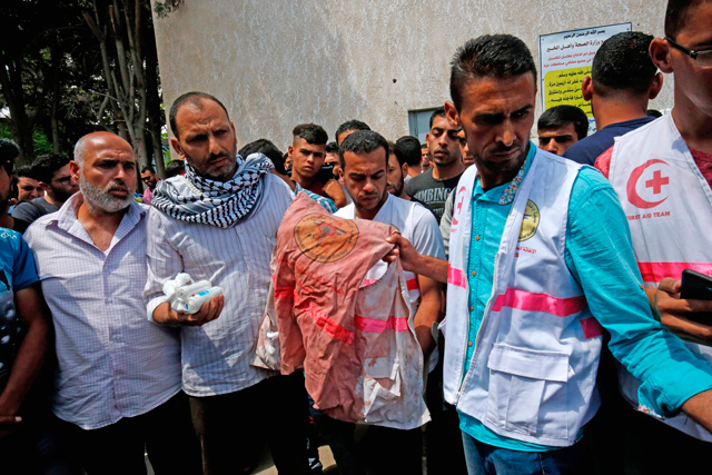 Father (2nd left) of 21-year-old medic Razan Al Najjar holds her jacket covered with blood during her funeral after she was shot dead by Israeli occupation forces in Khan Younis on Saturday (AFP  photo)
